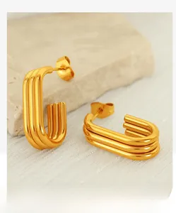Detailed macro view of gold U-shaped earrings featuring vertical striped metal texture