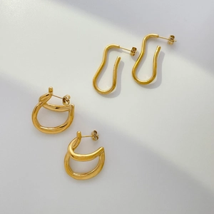 Modern abstract geometric gold hoop earrings with irregular curved lines on white background