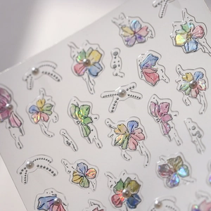 Laser holographic floral and pearl bow nail art stickers on a transparent sheet