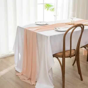Close-up of elegant peach chiffon table runner with soft drapes and sheer texture