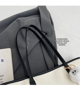 Dettaglio della tracolla in pelle nera resistente e cuciture sulla borsa tote minimalista