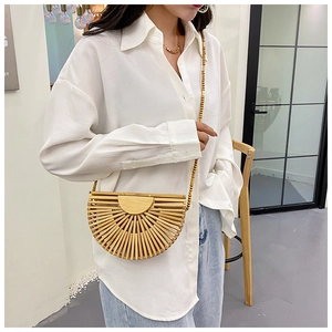 Detail of a semi-circular bamboo woven bag featuring a stylish wooden bead shoulder strap