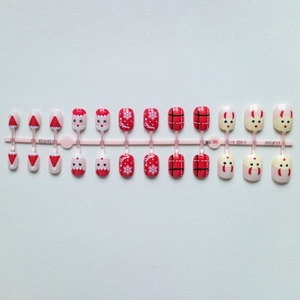 Detailed flat lay of Christmas press-on nails with reindeer and snowflake patterns