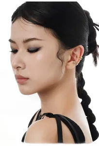 Detail of gold double-line and silver irregular textured ear cuffs on a model