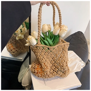 Close-up of khaki handmade woven tote bag with hollow mesh design and bohemian style