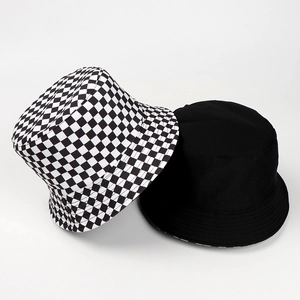 Detail view of reversible sun hat with black and white checkerboard and plain black finish