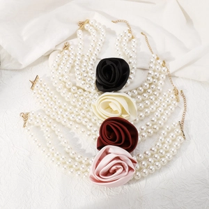 Detailed macro view of triple-layer pearl necklace with elegant silk rose pendants