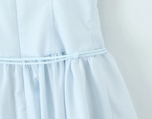 Détail du tissu texturé bleu clair avec cordon de serrage au niveau de la taille