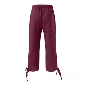 Detail of dark red linen pants featuring elastic waistband and lace-up hem design