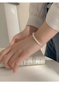 Detailed view of s925 sterling silver bracelet with freshwater pearls on female wrist