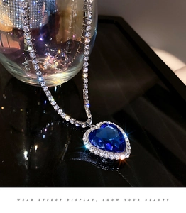 Detail einer funkelnden blauen Herz-Halskette mit silbernem Zirkonia-Besatz