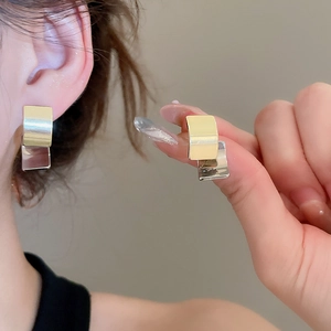 Detail showing two-tone geometric square earrings in gold and silver finish