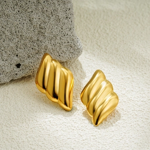 Macro shot of 18K gold plated stainless steel earrings with textured wave design