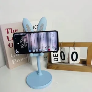 Adjustable light blue rabbit ear desktop phone stand holding smartphone in landscape view