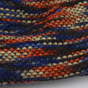 Close-up of thick knitted beanie with colorful stripes and star stitch pattern for warmth