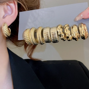 Detail of vintage gold hoop earring set with textured bead and twisted rope patterns