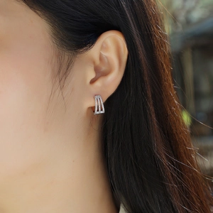 Close-up of elegant double-row moissanite silver hoop earrings worn on earlobe