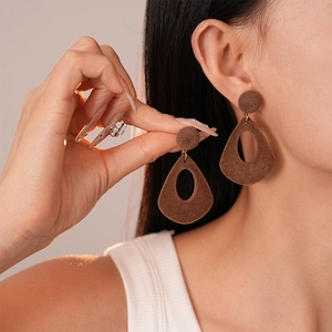 Boucles d'oreilles rétro marron en forme de larme avec lien doré sur modèle