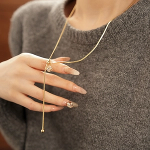 Detail of a gold-plated snake chain Y-necklace with a sparkling cubic zirconia pendant