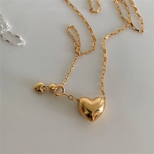 Close-up of a 3D gold heart pendant with detailed rectangular link chain necklace