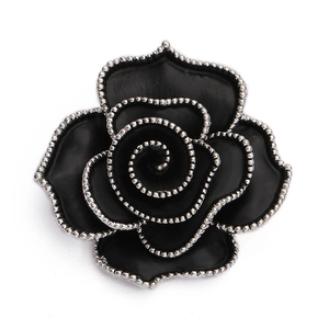 Macro shot of black rose brooch with silver beaded edges and detailed enamel texture