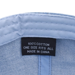 Detail of internal care label on washed denim baseball cap made of 100% pure cotton