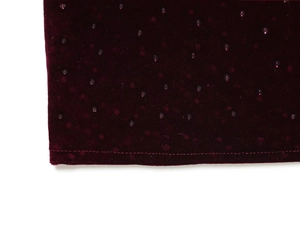 Macro view of burgundy velvet fabric featuring rhinestones and high-quality hem stitching