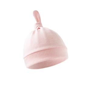 Macro detail of soft pink cotton newborn hat featuring a top knotted tail design