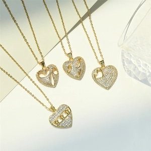 Vue détaillée de quatre pendentifs cœur plaqués or avec zircons et motifs ajourés