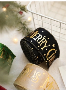 Close-up of festive Christmas ribbons with gold foil Merry Christmas text and stars