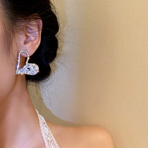 Macro shot of a sparkling heart earring with pave cubic zirconia on a female model
