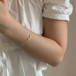 Detail of S925 sterling silver infinity symbol bracelet worn on a female wrist