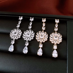 Close-up of luxury gold and silver tassel earrings with crystals in a leather box