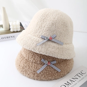 Winter plush bucket hat with bow detail in cream and brown, stylish fuzzy fisherman cap