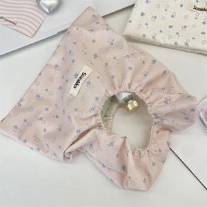 Dettaglio della borsa in tela a fiori rosa con manico elastico e etichetta Sozakka