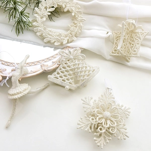 Elegant cream Christmas glitter ornaments including snowflakes and bells on silk