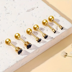 Detail of six gold surgical steel stud earrings featuring black cubic zirconia stones