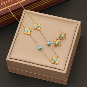 Vintage gold stainless steel necklace set with turquoise flower charms on jewelry box