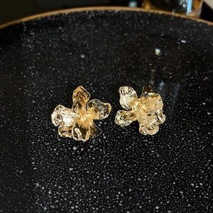 Detail view of gold vintage triangle earrings with diamonds on a textured plate