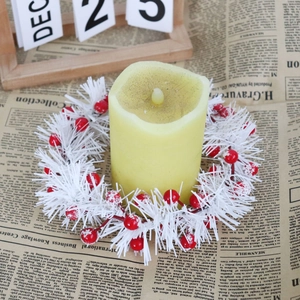 Winter candle ring with white PVC needles and red berries on a pillar candle