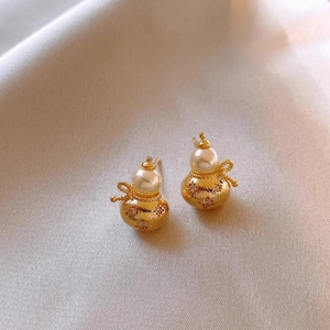 Elegant gold gourd earrings with white pearls and sparkling star engravings on silk