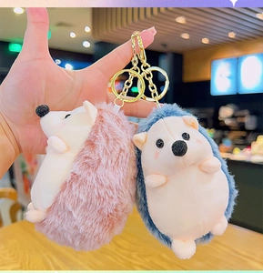 Detailed view of plush hedgehog keychains in pink and blue with golden metal rings