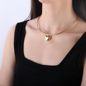 Macro view of gold-plated snake chain necklace with a 3D polished heart pendant