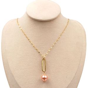 Golden chain necklace with textured metal oval and a pink pearl pendant on a neck model
