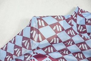 Detail view of the breathable mesh fabric with red and blue plaid print on a bodycon dress