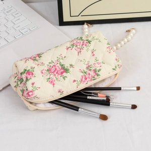 Detail of quilted floral makeup bag with pink roses and luxury pearl carry strap
