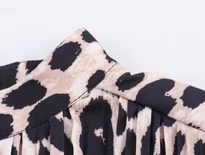 Detail shot of the V-neckline with pleated fabric in a vintage leopard print pattern