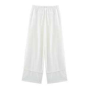 Detail of white wide-leg linen trousers showing elastic waistband and back pocket stitch