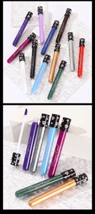 Detailed view of assorted matte lip gloss colors with skull patterned caps on clear surface