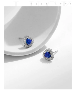 Gros plan d'une boucle d'oreille en argent S925 avec opale cœur bleu et diamants